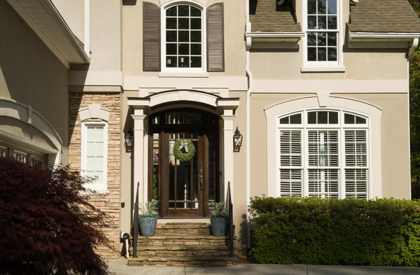 AFTER installation of arched roof portico with beige home and brown door