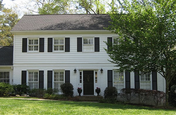 BEFORE traditional front porch on square white home with black shutters