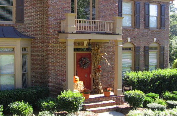 AFTER installation of arched roof portico on brick house with red door side view