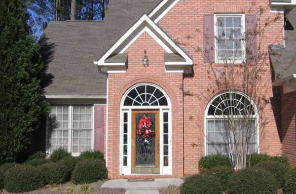 BEFORE installation of arched roof portico with brick home and wood and glass door