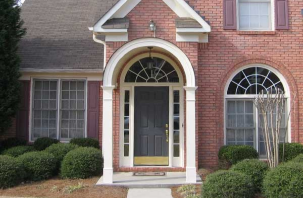 AFTER installation of arched roof portico with brick home and wood and glass door