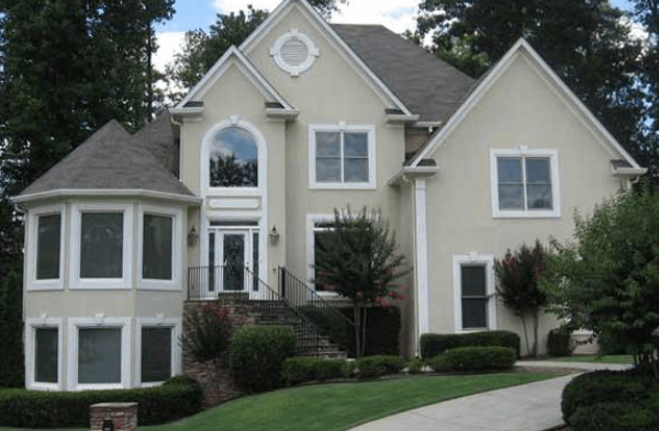 BEFORE installation of contemporary half porch on beige stucco home with white trim