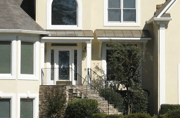 contemporary half porch on beige stucco home with white trim