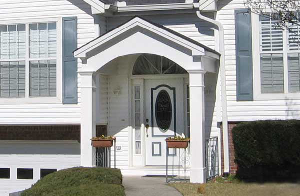 AFTER installation of gabled roof portico on white shingle home with white door