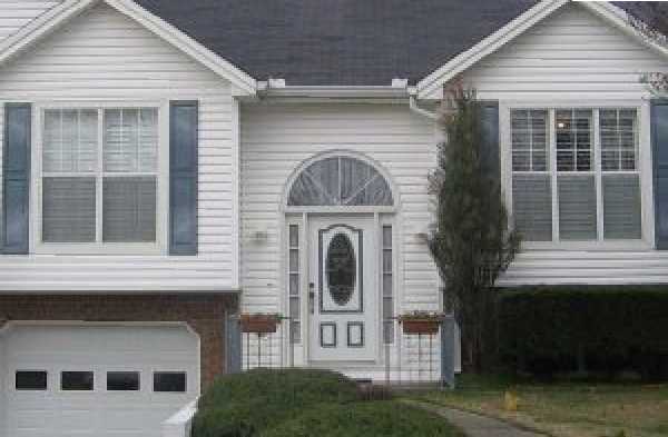 BEFORE installation of gabled roof portico on white shingle home with white door