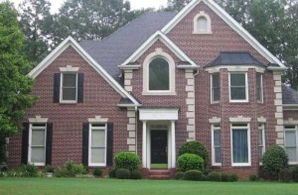 BEFORE installation of hip roof portico on brick house with black shutters and white trim