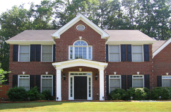 AFTER installation of a gable roof portico with square columns on large brick house