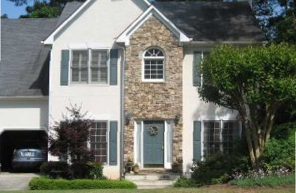 BEFORE installation of hip roof portico on stone and white house with blue shutters