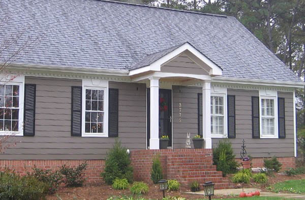 AFTER installation of gabled roof portico on grey shingled home with black shutters