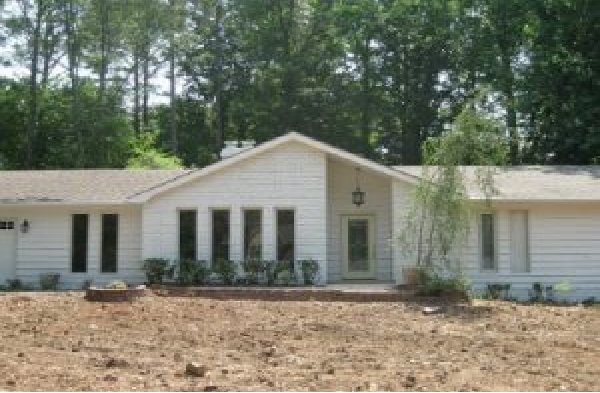 BEFORE installation of gabled roof portico with with wooden columns on white brick rancher