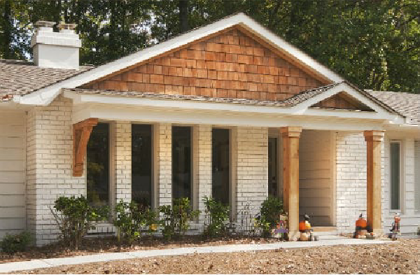 AFTER installation of gabled roof portico with with wooden columns on white brick rancher