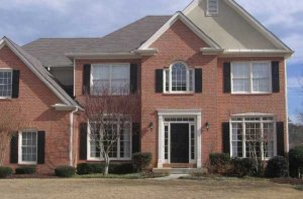 BEFORE installation of gabled roof portico with double white columns on brick home