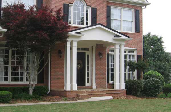 AFTER installation of gabled roof portico with double white columns on brick home