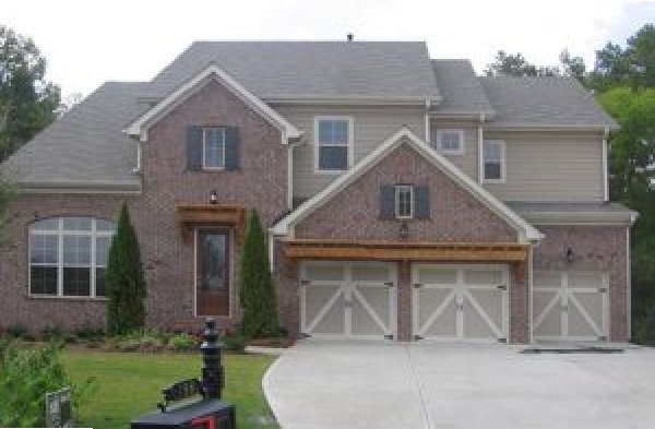 BEFORE installation of gabled roof portico with wood shingles on brick home with two car garage