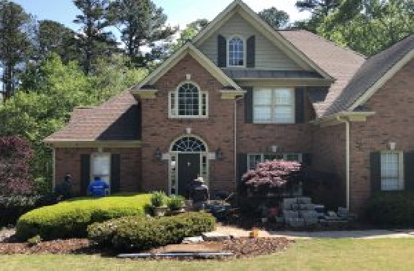 BEFORE installation of gabled roof portico with white circular columns on brick home