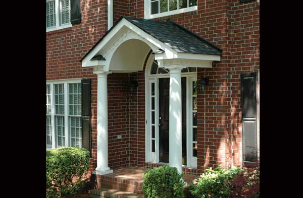 AFTER installation of gabled roof portico on brick home with white columns side view