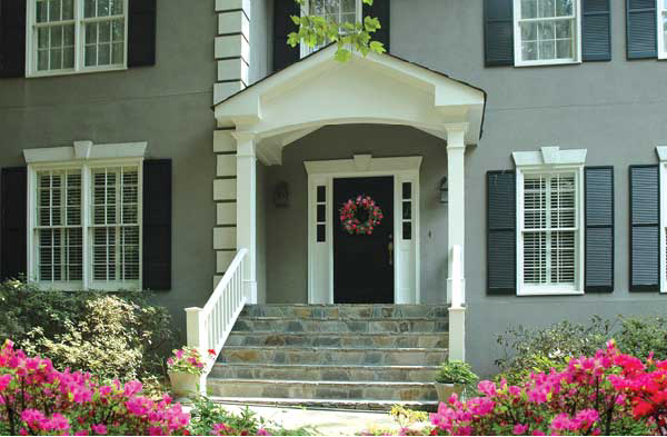 AFTER installation of gabled roof portico on grey home with black shutters and stone steps