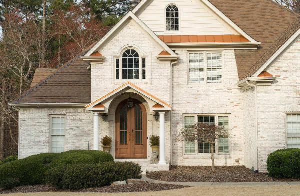 AFTER installation of gabled roof portico with white circular columns on white brick home