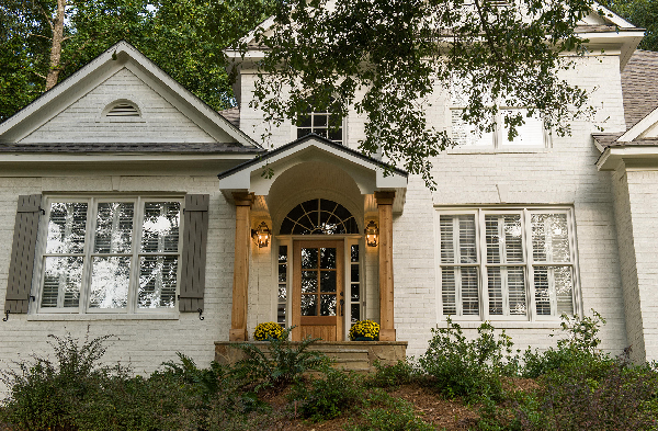 AFTER installation of gabled roof portico with wooden columns on white brick home