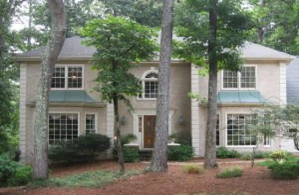 BEFORE installation of hip roof portico on tan stucco house