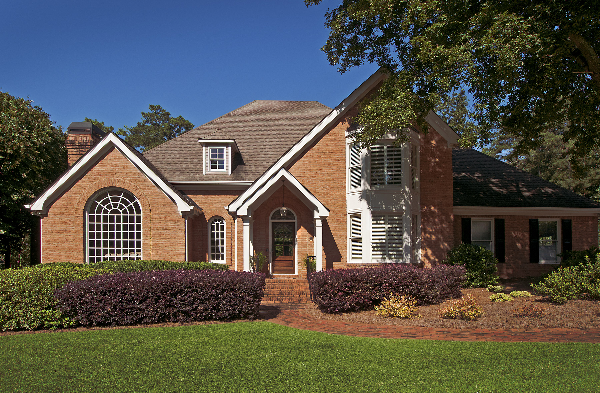 AFTER installation of a gable roof portico with square columns on large brick house with front round top window