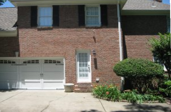 BEFORE side back door portico on brick home with white garage door