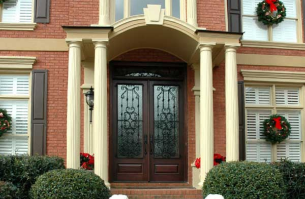 AFTER installation of arched roof portico with brick home and black shutters on long windows