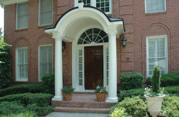 AFTER installation of arched roof portico on brick house with wood door and white trim