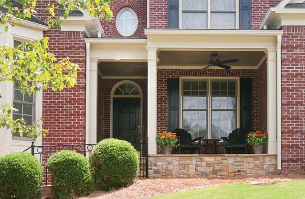 AFTER installation of front porch of brick home with white bay window