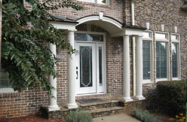 AFTER installation of arched roof portico with brick home and long windows/doors