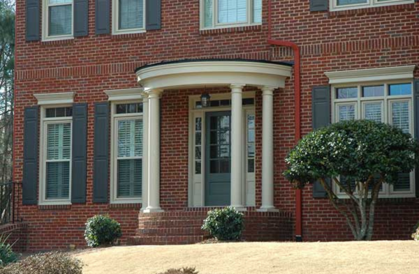 AFTER installation of round portico with white columns on brick home