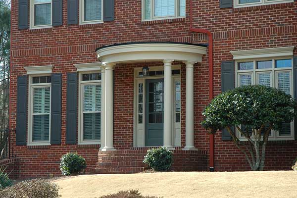 AFTER installation of round portico with white columns on brick home 2