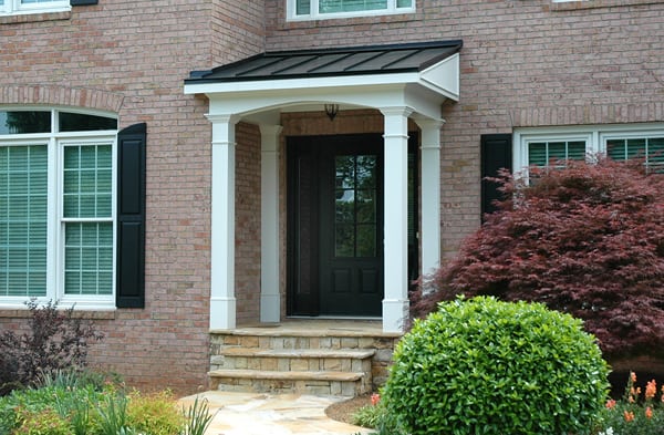 AFTER installation of shed roof portico on brick home with black shutters