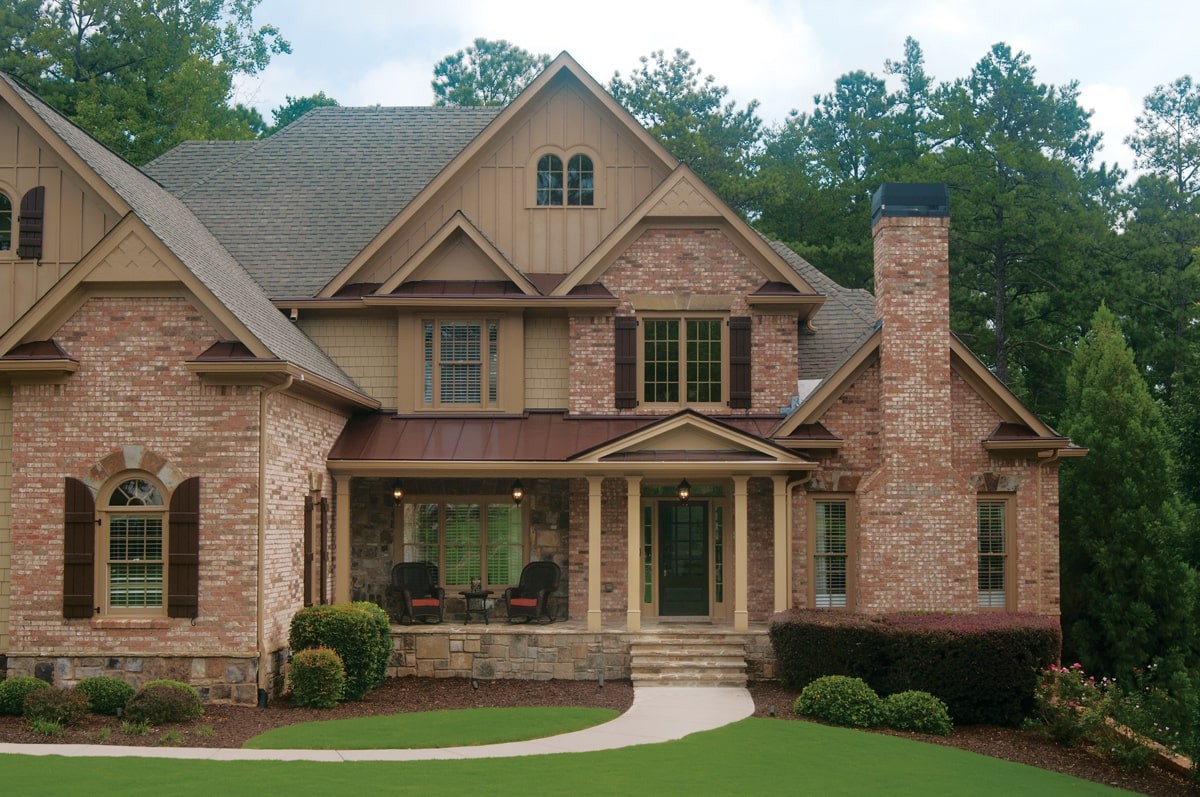 AFTER installation of portico on large multi-colored brick home up close