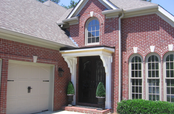 AFTER installation of bracket portico with brown door on brick home