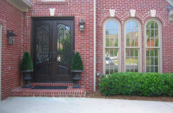 BEFORE installation of bracket portico with brown door on brick home