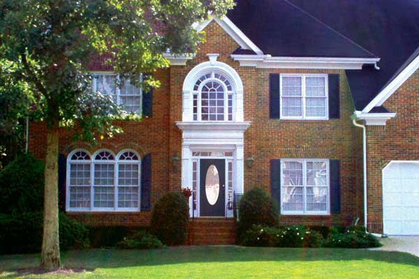 BEFORE installation of traditional front porch on square brick home with tree infront of house