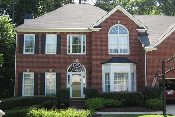 BEFORE installation of traditional front porch on square brick home with American flag colors banner on top of front door