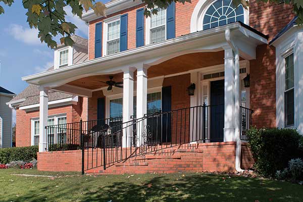 AFTER installation of traditional front half porch on brick house with blue shutters