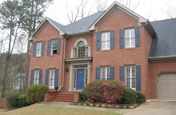 BEFORE installation of shed roof portico on brick home with blue shutters