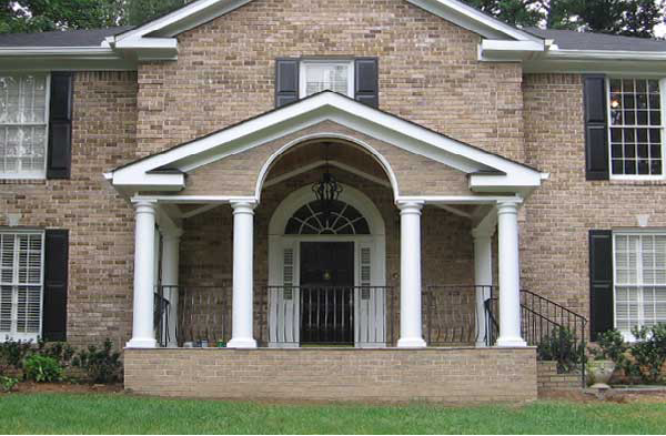 AFTER installation of gabled roof portico with white columns on brick home