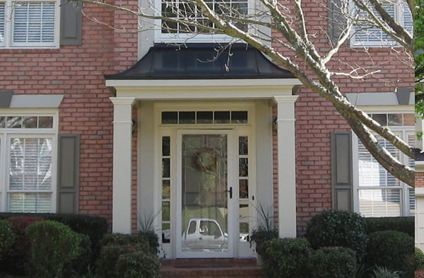 AFTER installation of hip roof portico on brick house with white trim