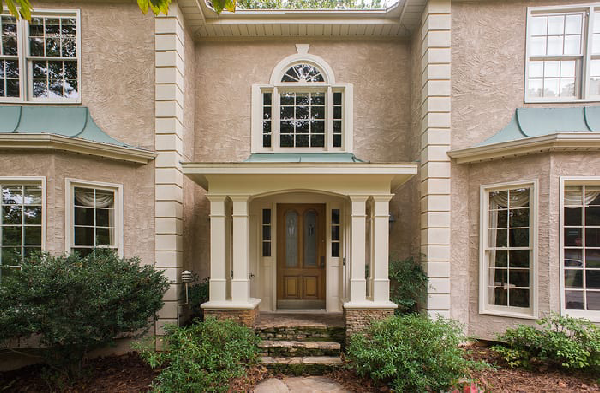 AFTER installation of hip roof portico on tan stucco house