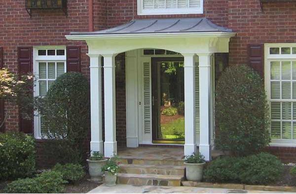 AFTER installation of hip roof portico on brick house with burgundy shutters