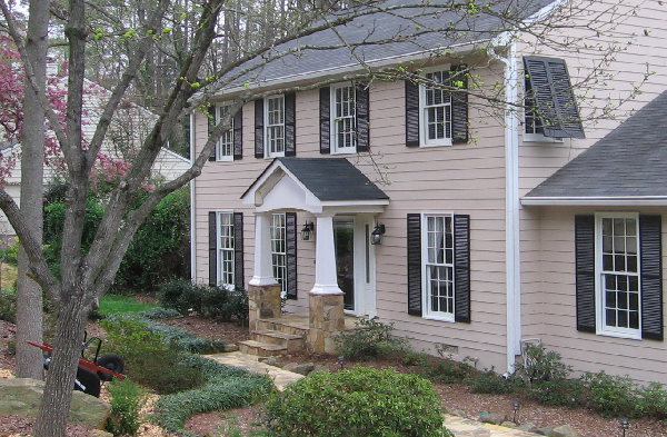 AFTER installation of gabled roof portico on beige shingled home