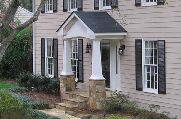 close up AFTER installation of gabled roof portico on beige shingled home