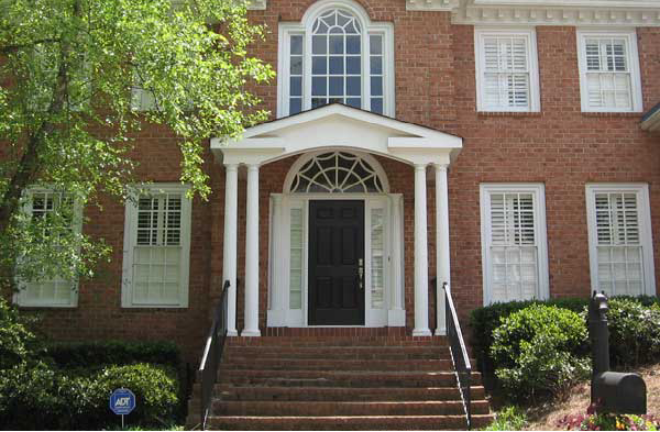 AFTER installation of gabled roof portico with white columns on brick home with brick steps