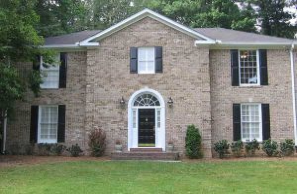 BEFORE installation of gabled roof portico with white columns on brick home