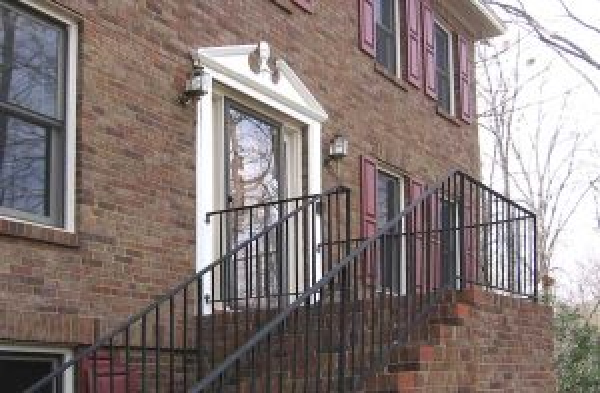 BEFORE installation of gabled roof portico on brick home with metal railing