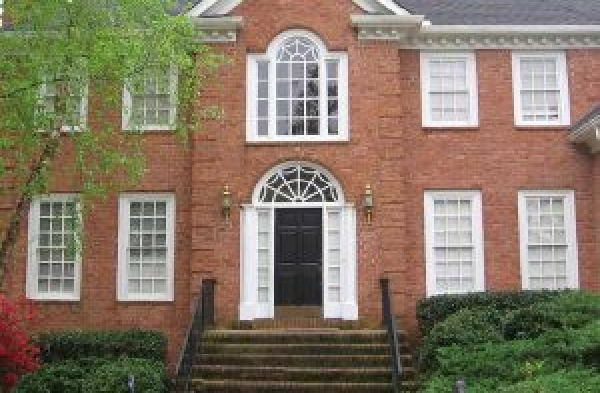 BEFORE installation of gabled roof portico with white columns on brick home with brick steps